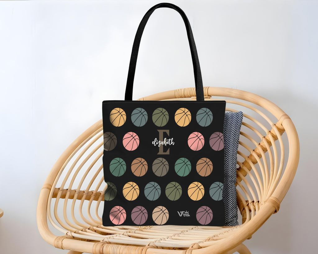 Black tote bag with colorful basketball pattern on a wicker chair