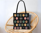 Black tote bag with colorful basketball pattern on a wicker chair