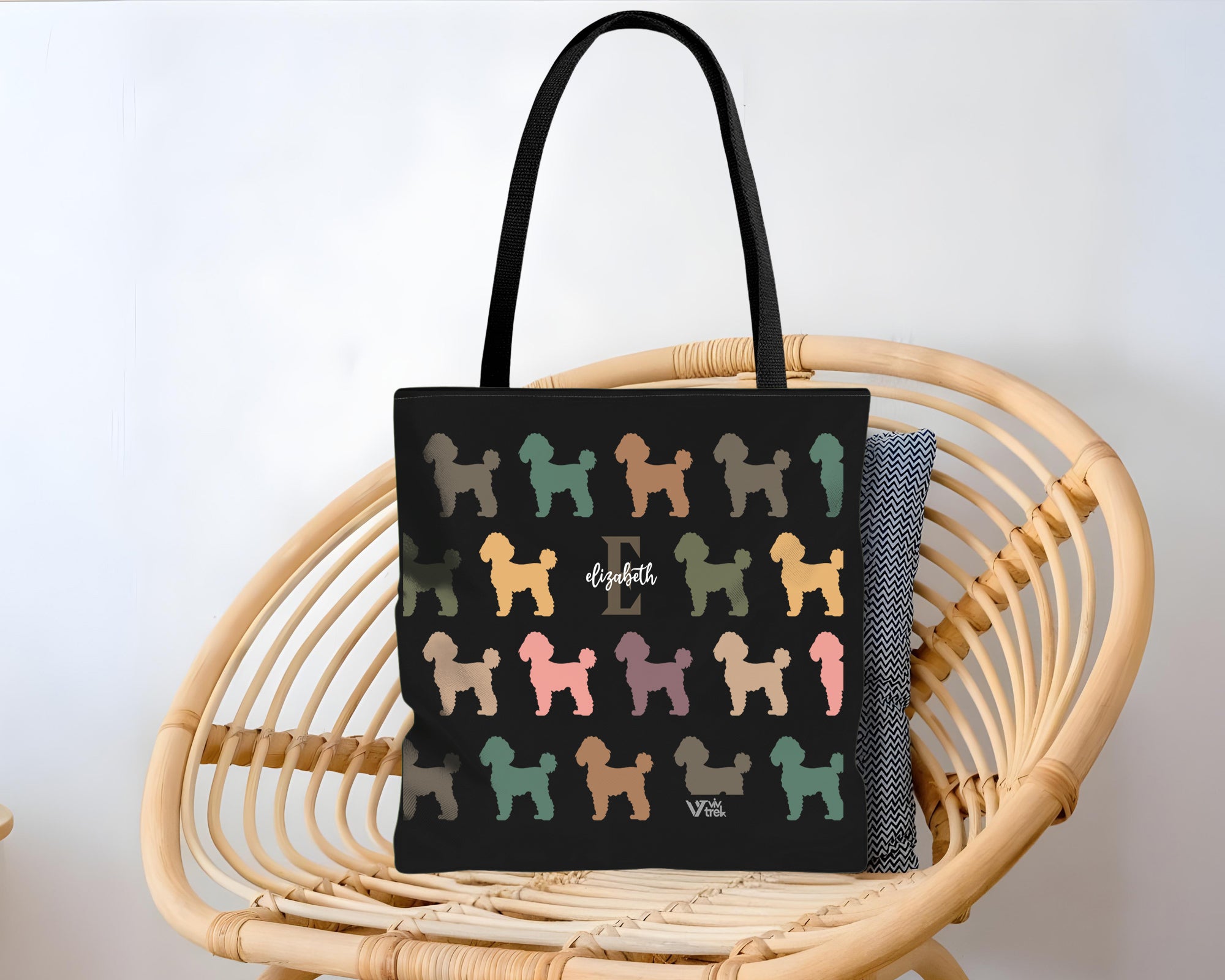 Black tote bag with colorful dog pattern and initial name text