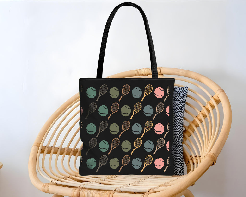 Black tote bag with colorful patterns on a wicker chair against a white background