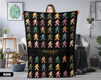 Person holding a black blanket with colorful 'bigfoot' pattern and name in a room.