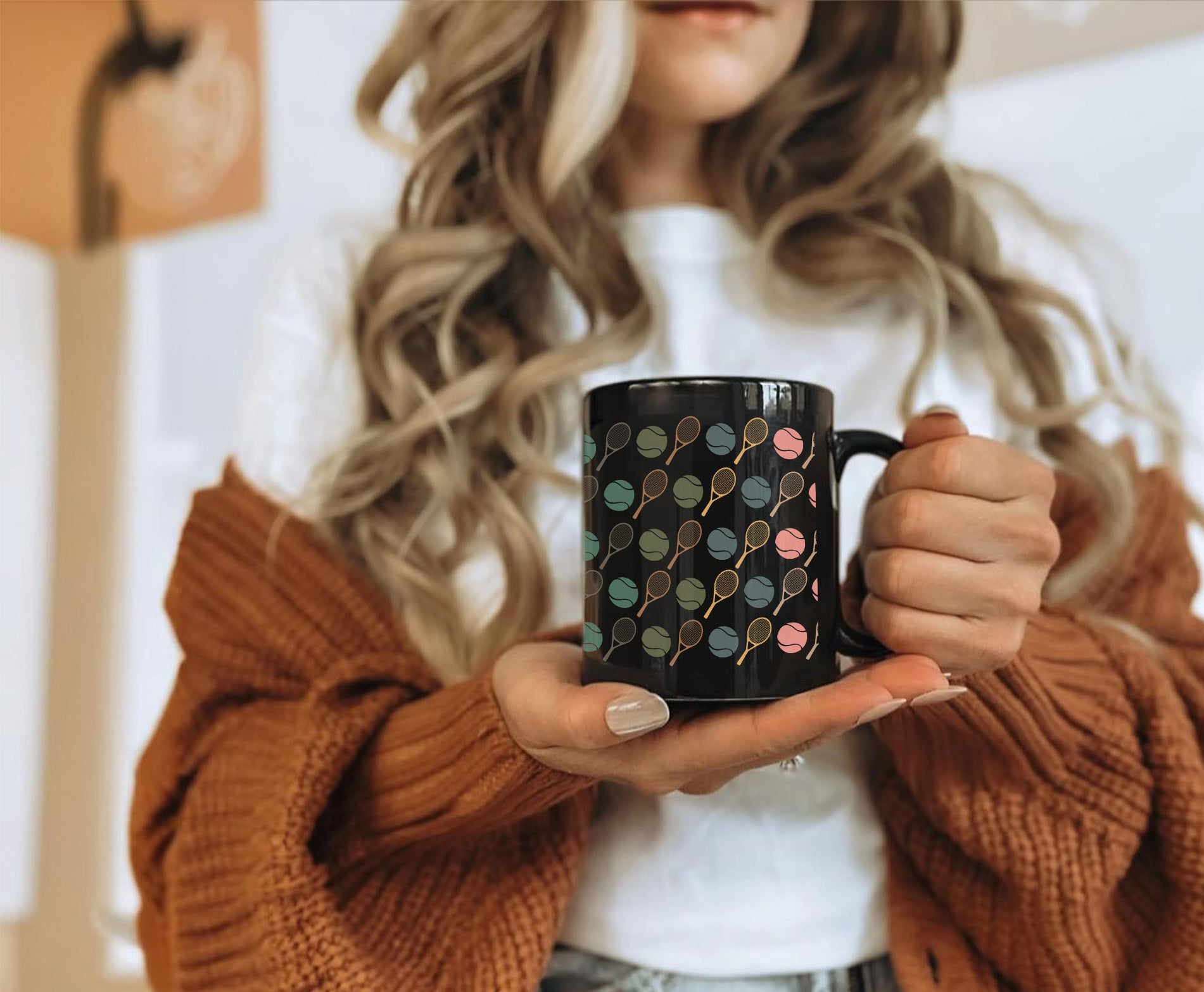 Person holding a black mug with a colorful pattern