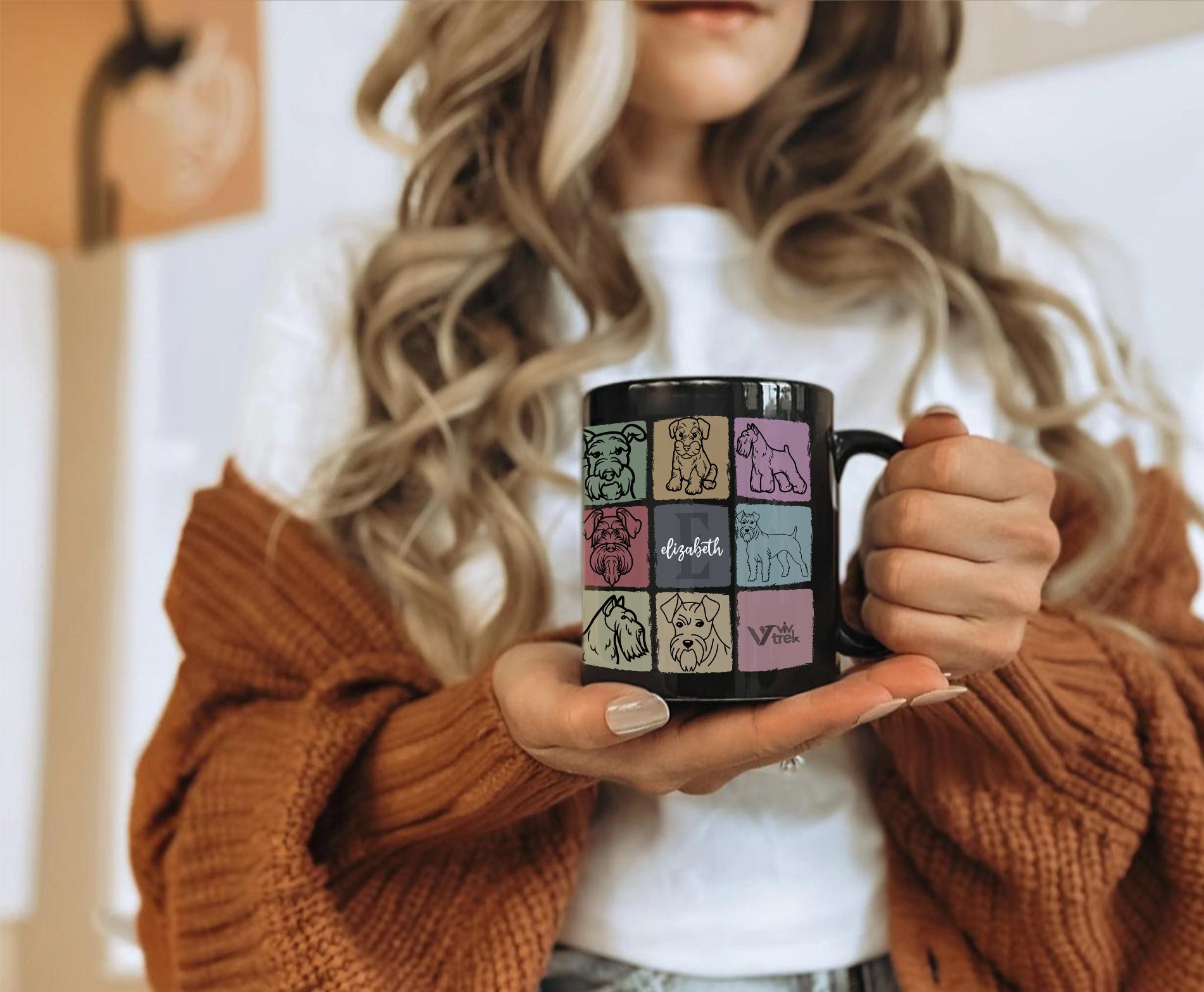 Person holding a black mug with name text and colorful designs