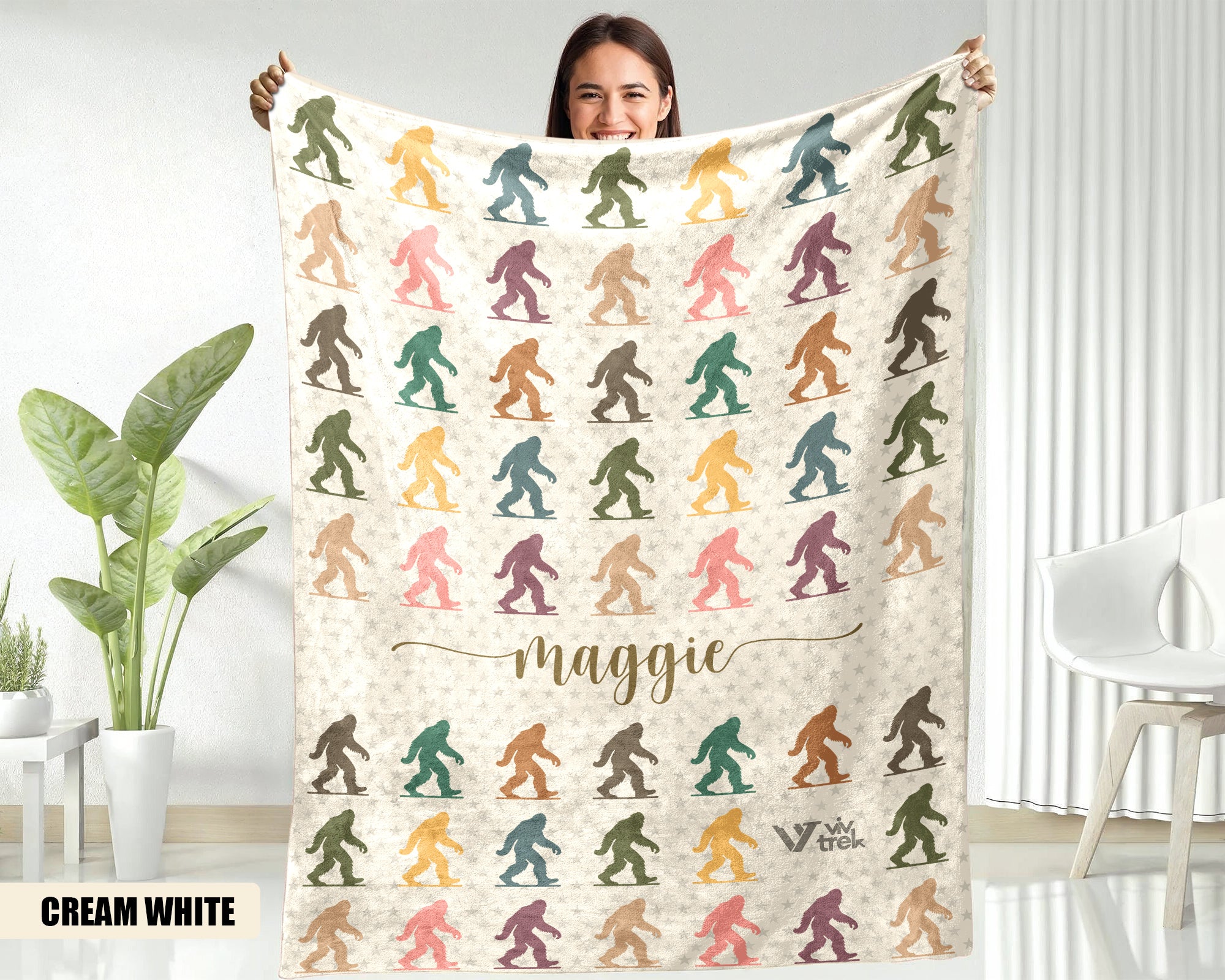Person holding a blanket with colorful Bigfoot patterns and the name text on a  background.