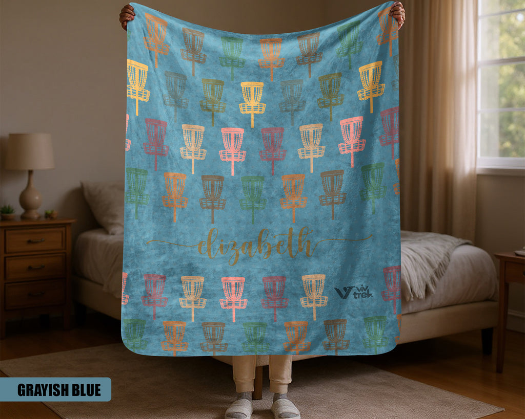 Person holding a blue Disk Golf blanket with colorful pattern in a room.