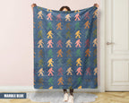 Person holding a colorful 'Bigfoot' pattern blanket with a marble blue background.