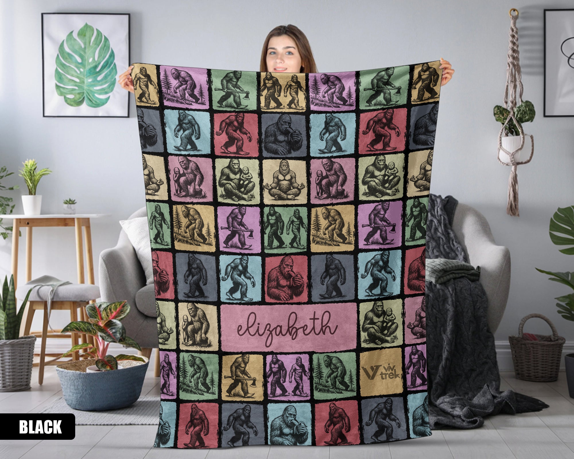 Person holding a colorful bigfoot blanket with patterns and name text in a room.