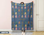 Person holding a colorful 'bigfoot' pattern blanket with name printed on it.