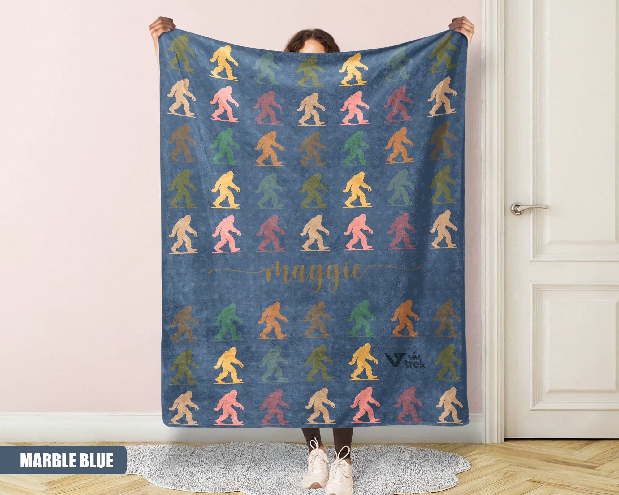 Person holding a colorful 'bigfoot' pattern blanket with name printed on it.