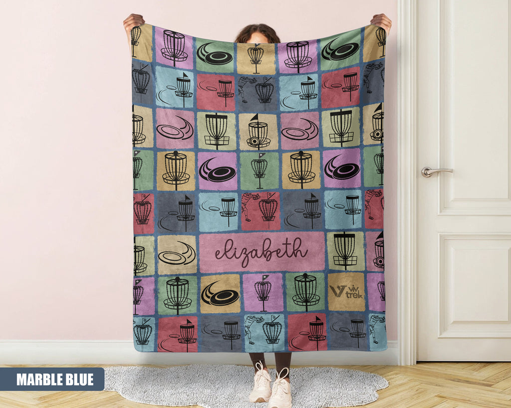 Person holding a colorful patterned disk golf blanket with name text printed on it.