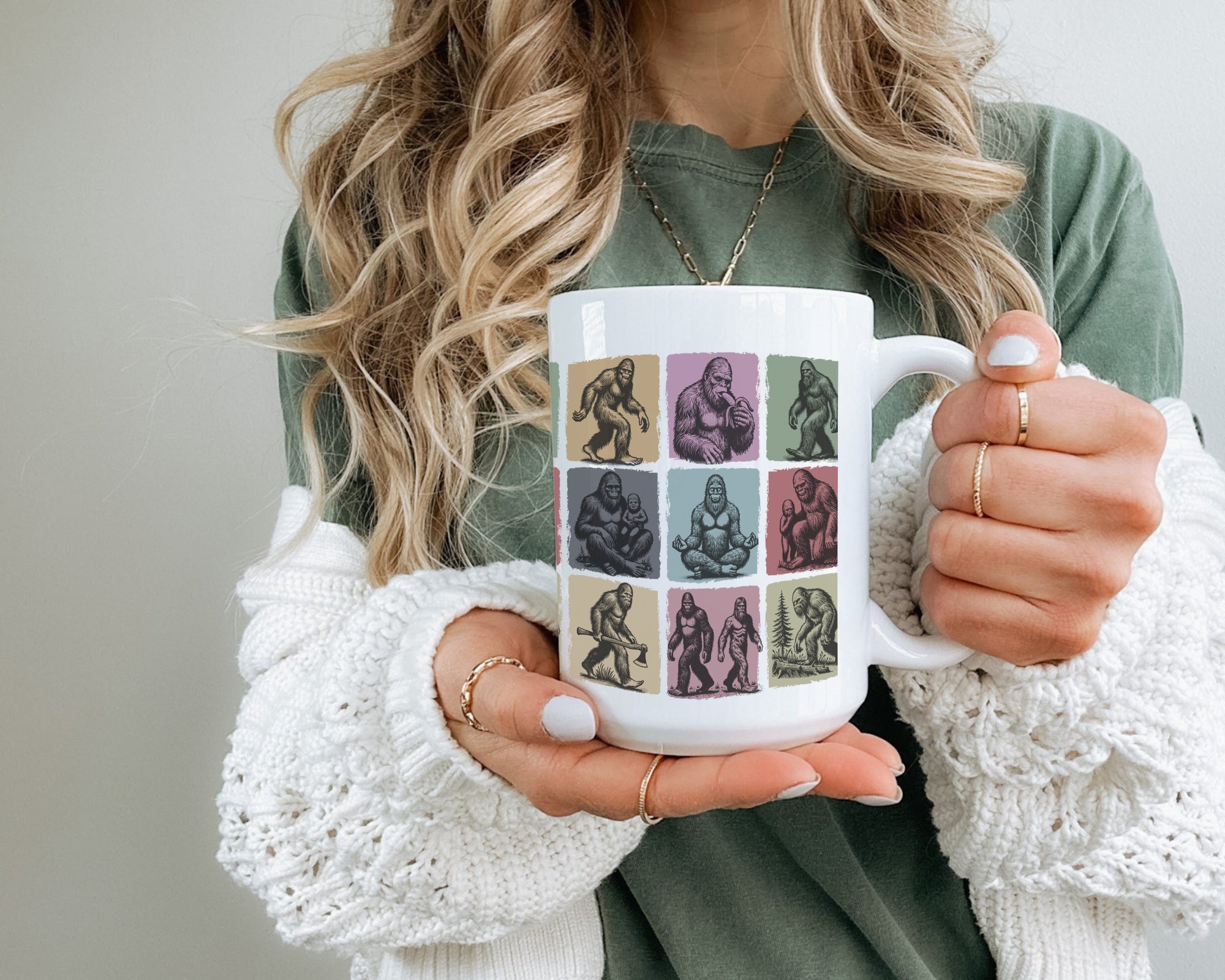 Person holding a mug with a colorful design of Bigfoot.