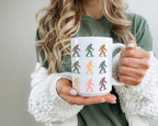 Person holding a mug with colorful bigfoot design
