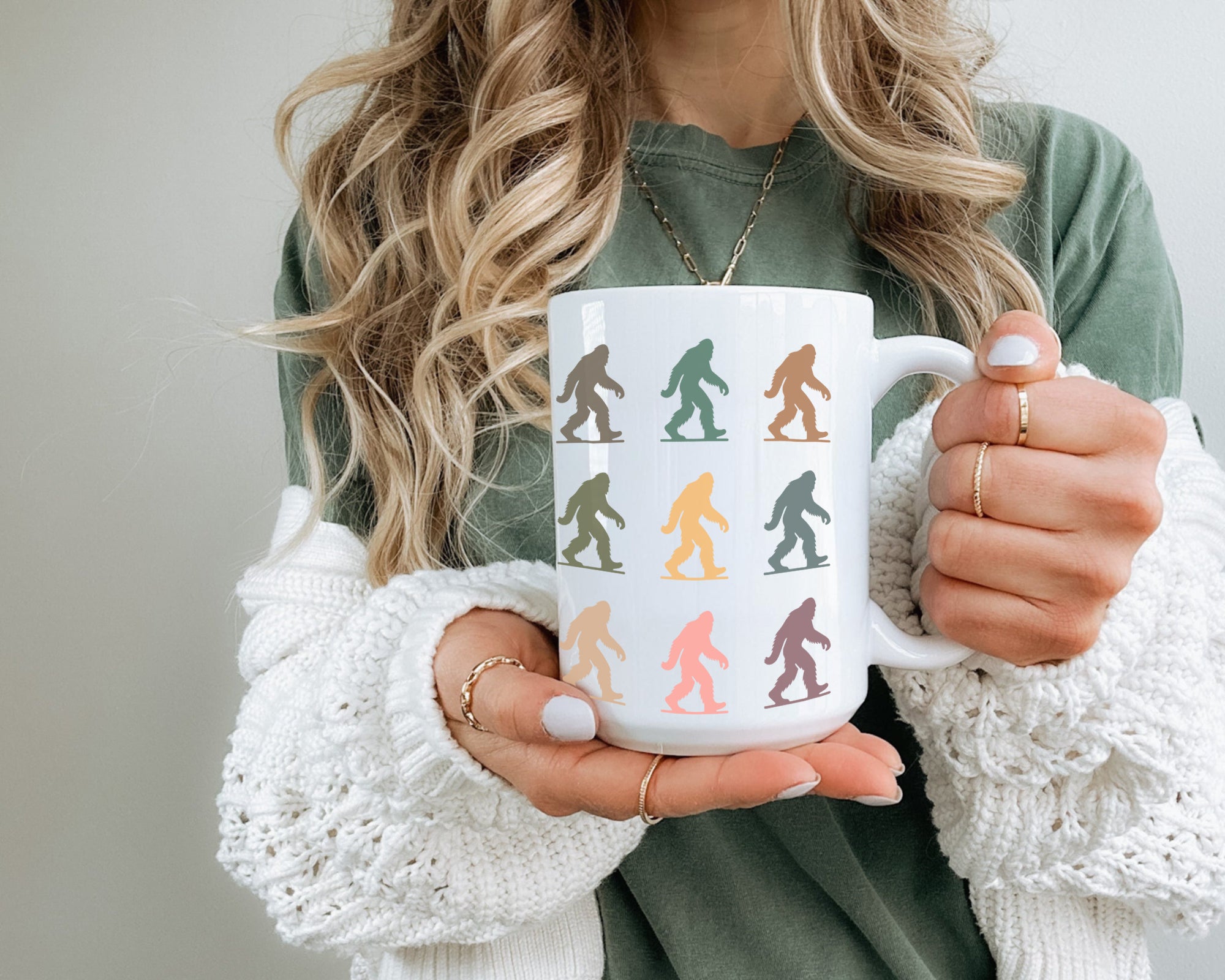 Person holding a mug with colorful bigfoot design