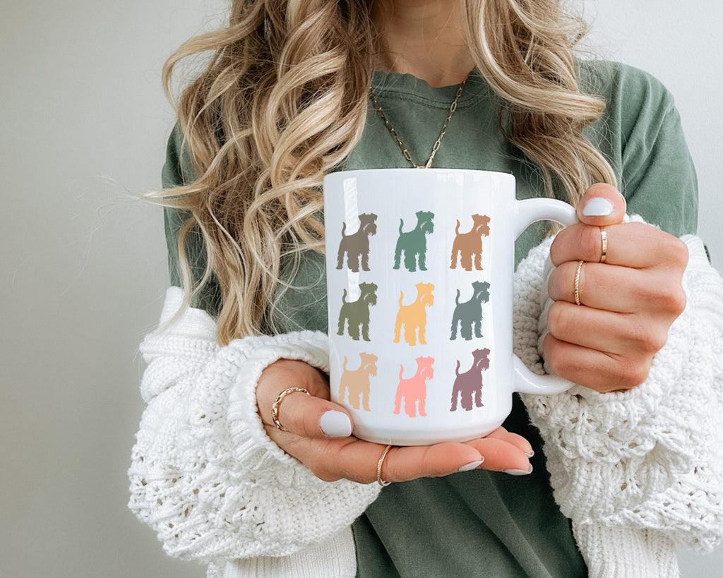 Person holding a mug with colorful dog illustrations