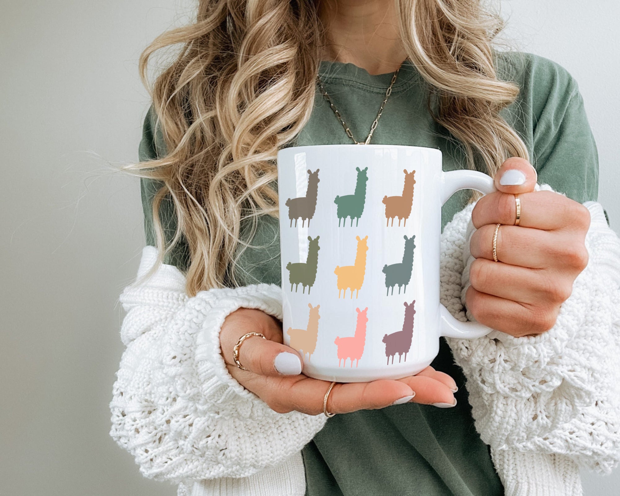 Person holding a mug with colorful llama design