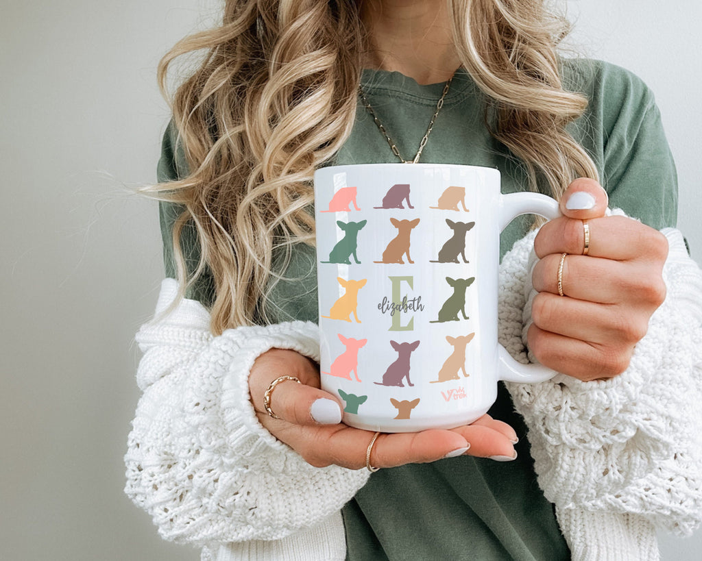 Person holding a mug with dog pattern and initial name text
