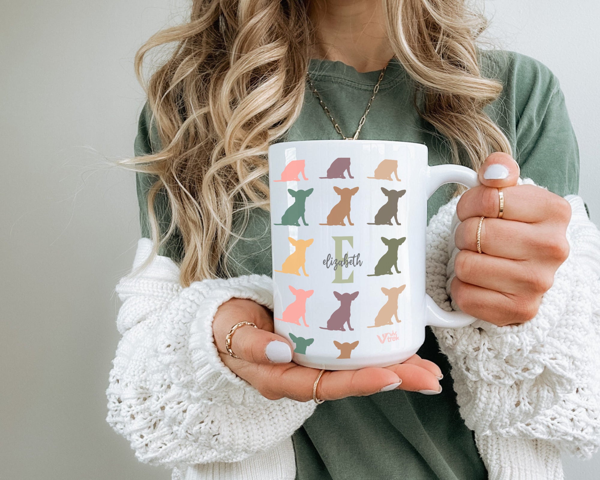 Person holding a mug with dog pattern and initial name text