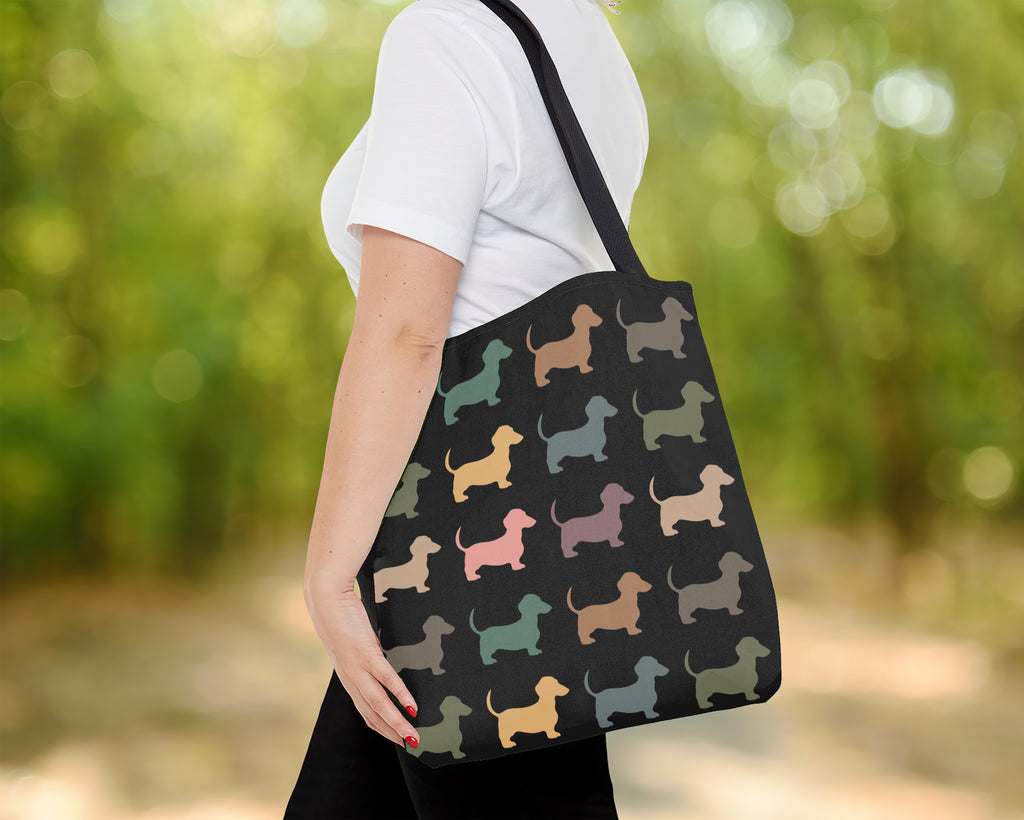 Person holding a tote bag with dachshund pattern outdoors