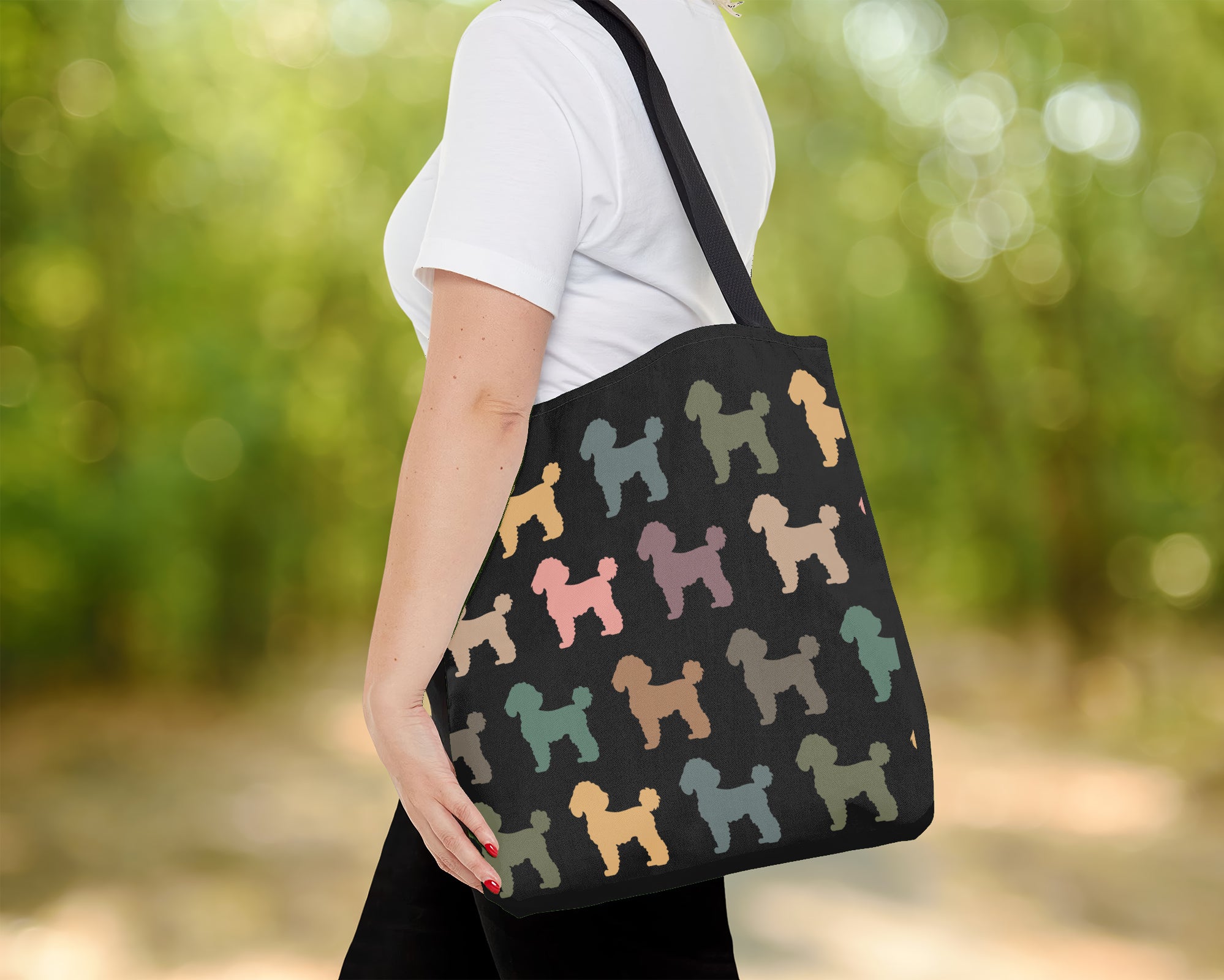 Person holding a tote bag with dog pattern in an outdoor setting