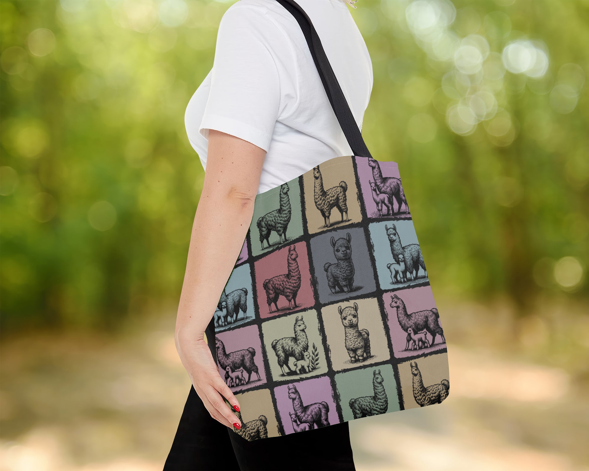 Person holding a tote bag with llama pattern outdoors.