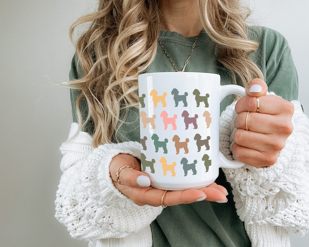 Person holding a white mug with colorful dog pattern