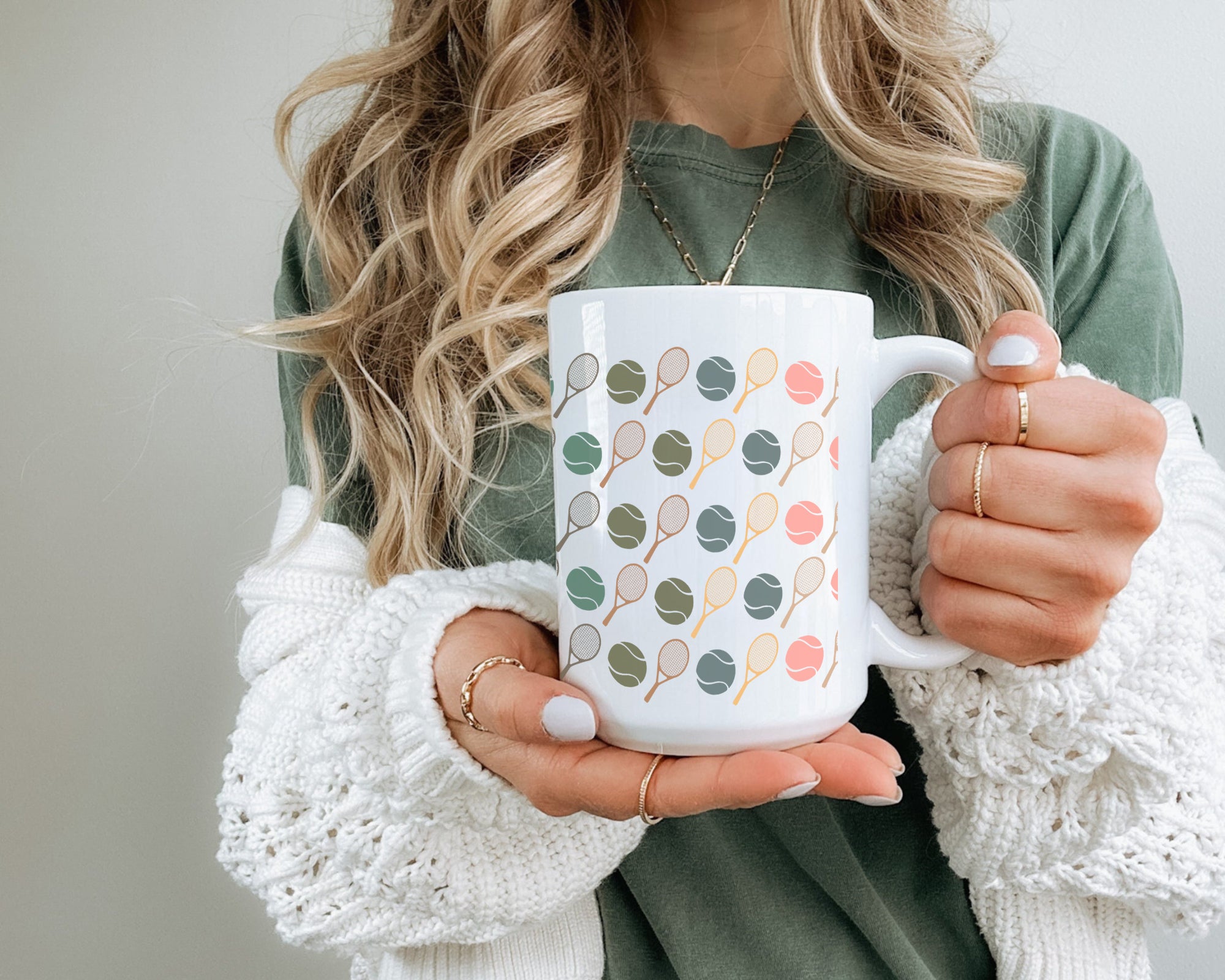Person holding a white mug with colorful patterns